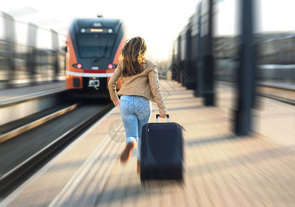火车晚点的女人游客在车站奔跑和追逐离开的火车有压力的人在平台上拉手提图片