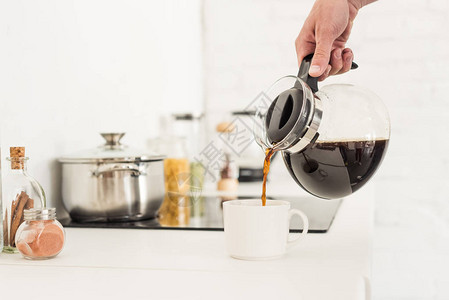 厨房的咖啡机将咖啡倒进茶杯中的图片