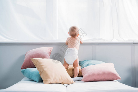 躺在床上的尿布里快乐的小婴儿枕头满图片