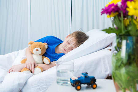可爱的小男孩睡在医院床上图片