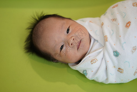 细小的亚洲小婴儿被包背景图片