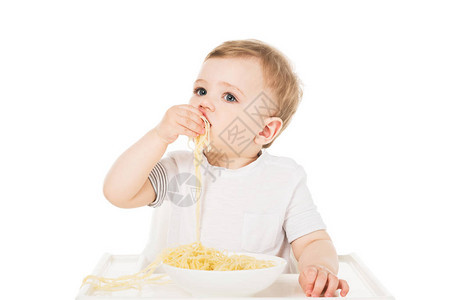 坐在高椅子上的小男孩用手吃意大利面图片