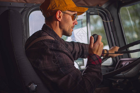 白种男子驾驶卡车司机在两条路无线电车图片