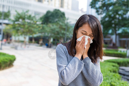 感冒的女商人打喷嚏用纸巾图片