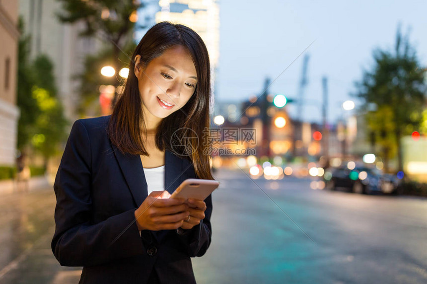 在东京市看手机的女商人图片