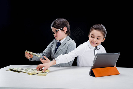用钱和石板玩商业游戏的小孩图片