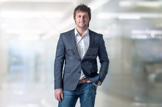 穿着便衣的帅男子站在办公室里用手图片