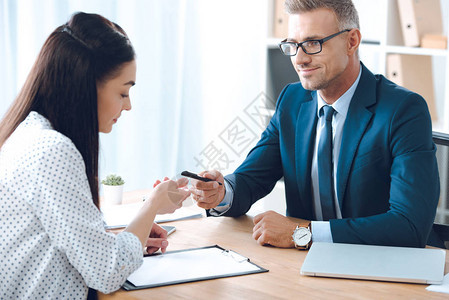 向女客户提供笔的微笑保险代理商在办公室桌面上签署文件时图片