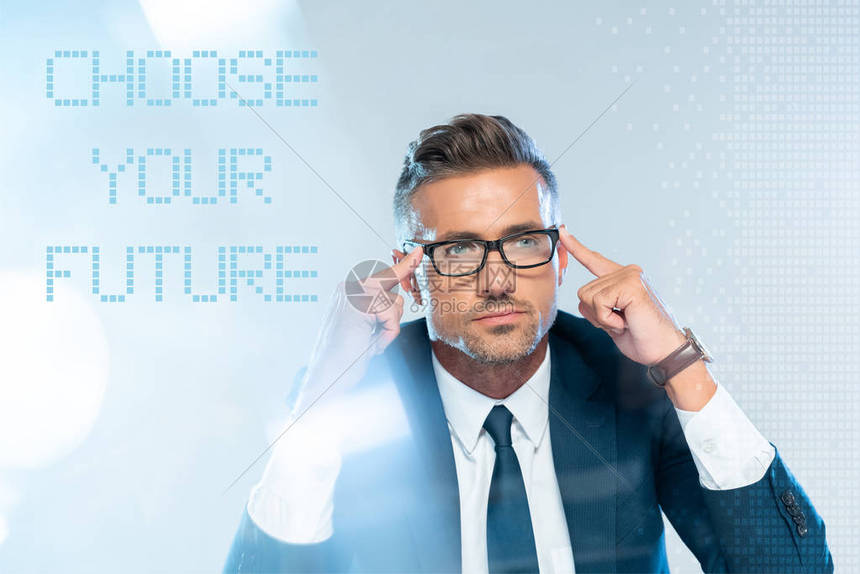 身戴眼镜的英俊商人触摸着被孤立在白色上的头部用选择你的未来字母图片