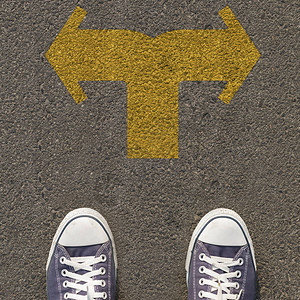 一双鞋站在马路上有双向黄色箭头图片