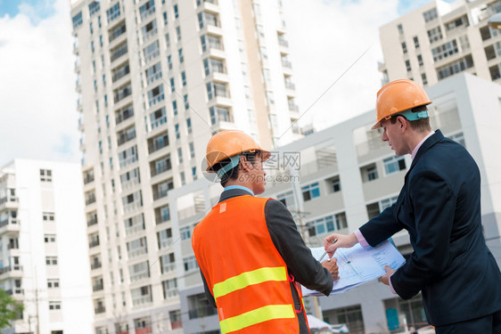 建筑师和客户讨论建筑工地的建筑计划图片