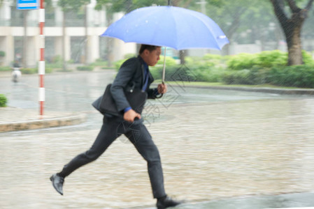 商人在大雨伞下快速户外奔跑的肖图片