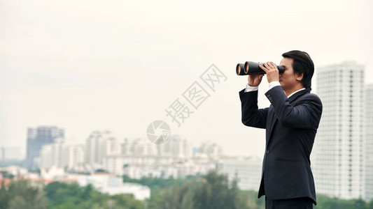 亚洲商人与双筒望远镜图片