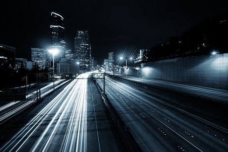 夜间西雅图市中心的公路和现代办公大楼上交通流量及图片