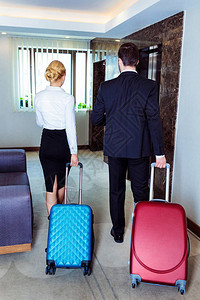 商务和女商人携带行李走到旅馆图片