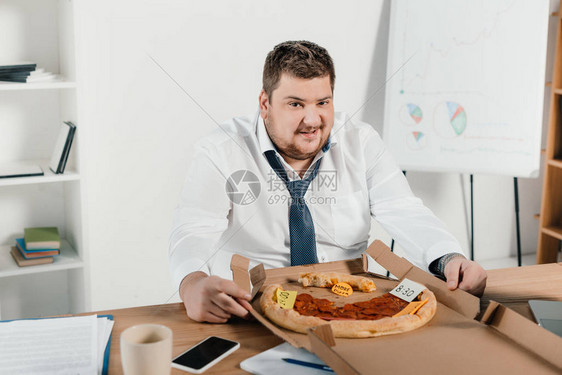 超重量体重商人在办公室工作图片