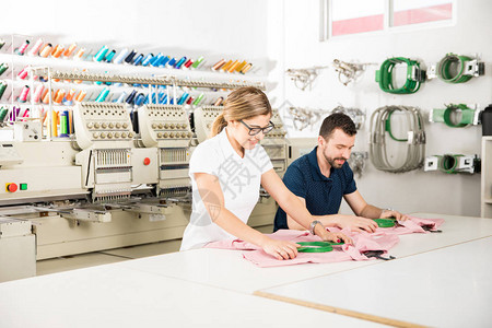 两个人在一家纺织厂准备刺绣衣图片