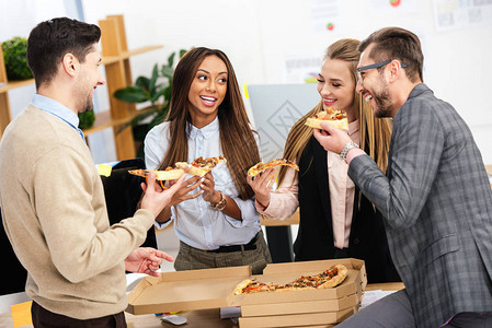 多族裔商人在办公室共食比萨图片