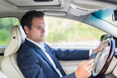 商人在开车时使用手机和发短信不注意道路危险的发短图片