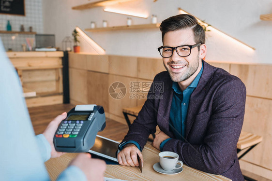 持信用卡在咖啡店支付订单的笑脸商人肖像照片图片