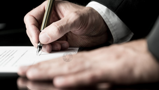 一名商人用喷泉笔签署合同其手背景图片