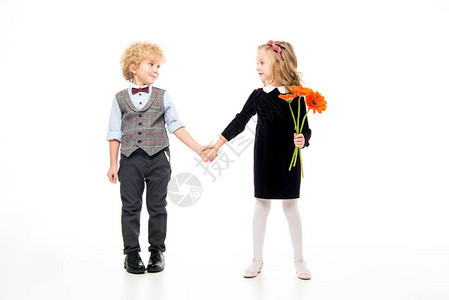 带着鲜花的美丽的小孩手握着鲜花在白图片