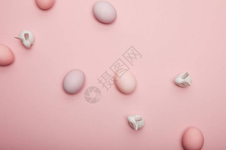 玩具的顶部视图和粉红色背景上的彩绘复活节彩蛋图片
