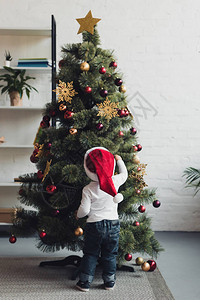在家中装饰圣诞树的圣塔帽图片