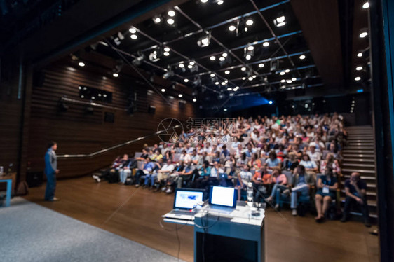 演讲者在科学会议上发表演讲的模糊形象会议厅的观众商图片