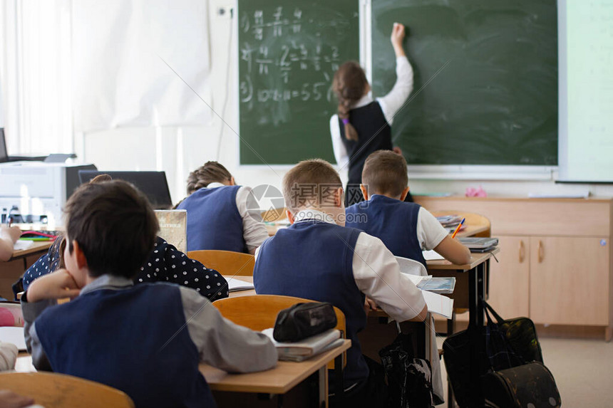 女孩少年女学生上课时在教室的黑板上写字教育培训儿童保育后视图高清图片下载-正版图片502600563-摄图网
