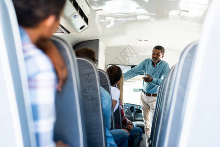 坐在校车上听成年的非裔美国教师讲话的青少年学图片