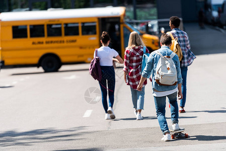 一组青少年学者乘车行驶到校车的图片