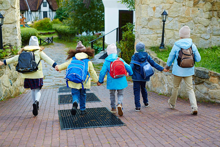 快乐的学童跑去学校的背影背景图片