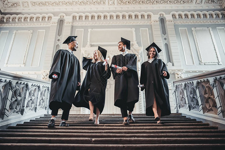 快乐的毕业生们在大学里走着楼梯在挂着图片