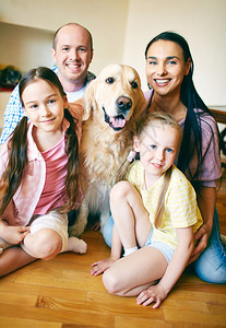 四口的年轻友好家庭和他们的狗在图片