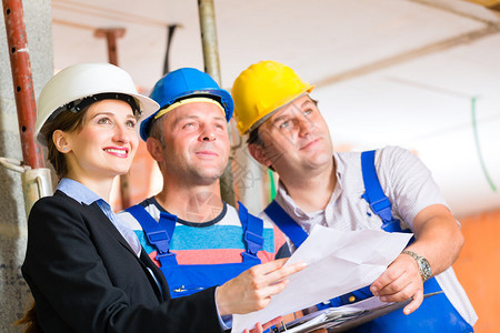 建筑工地团队或建筑师和建筑商或带头盔的工人控制或讨图片