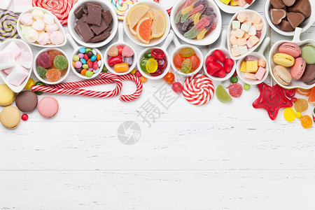 五颜六色的糖果棒糖杏仁饼棉花糖果酱巧克力和糖果带空间的顶视图片