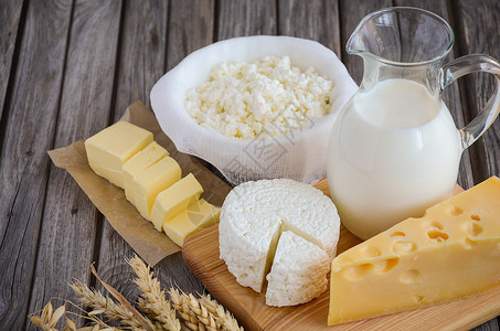 新鲜的乳制品牛奶酪黄油和奶酪与质朴的木制上的小麦横向许可图片