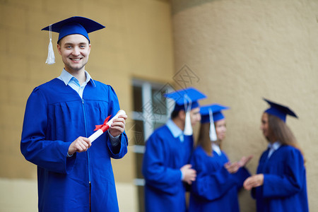 友好学生在毕业礼服上与前方有自图片