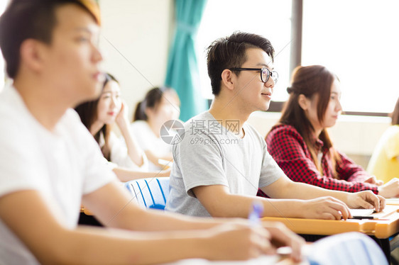 与同学们一起坐在一起的男大学生笑图片