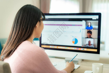 亚洲女商人在视频会议中与同事谈论计划的背影多民族业务团队使用计算机在视频通话中进行在线会议一群人在图片