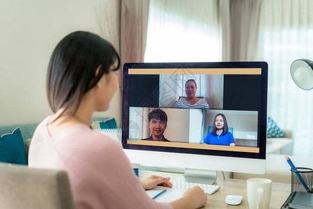 亚洲女商人在视频会议中与同事谈论计划的背影多民族业务团队使用计算机在视频通话中进行在线会议一群人在图片