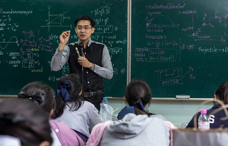 亚洲老师在科学实验室课堂上讲授白板上的物理公式高清图片下载-正版图片502619322-摄图网