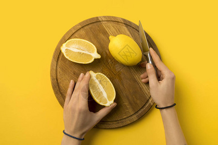 女在木板上切柠檬的作物形象图片