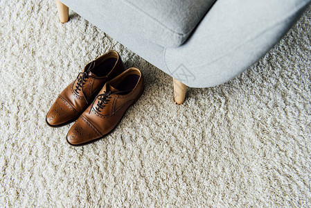紧的皮革牛福鞋在地毯上靠图片