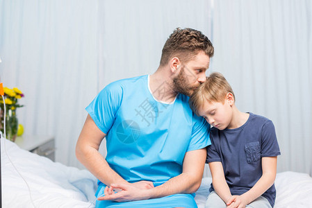 生病的父亲和心烦意乱的儿子一起坐在病床上图片