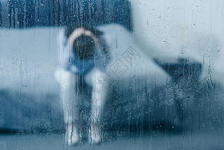 压抑的女士坐在床上用雨滴把头背景图片