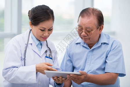 医生在触摸板上向病人展示他的结果图片