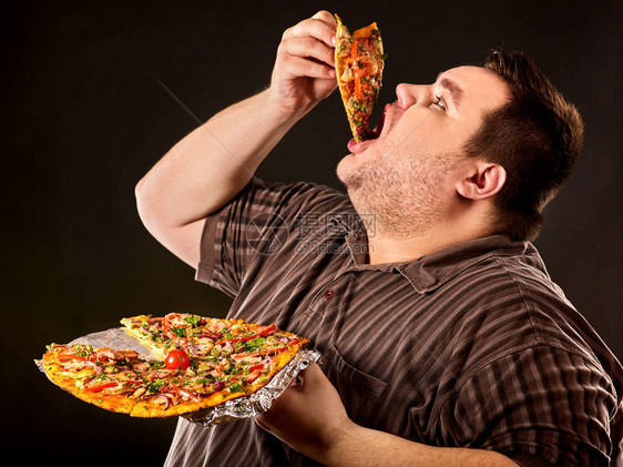 胖子在盘子上吃快餐片比萨饼的饮食失败为破坏健康食品的饥饿超重者关闭早餐他不能放图片