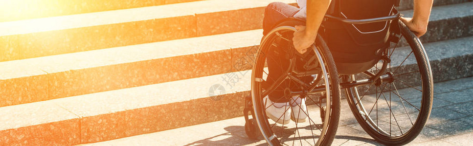 残疾人在街上使用轮椅并在没有斜坡的楼梯附近停图片